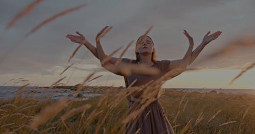 Women Performing among Spikes Swaying in Wind at Sunset