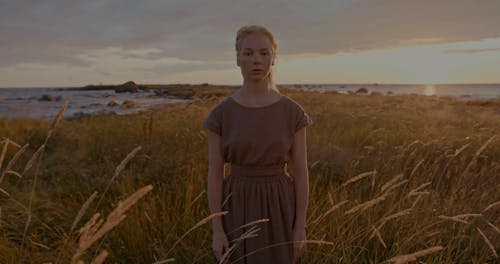 Women Performing in Seaside Grass Field at Sunset