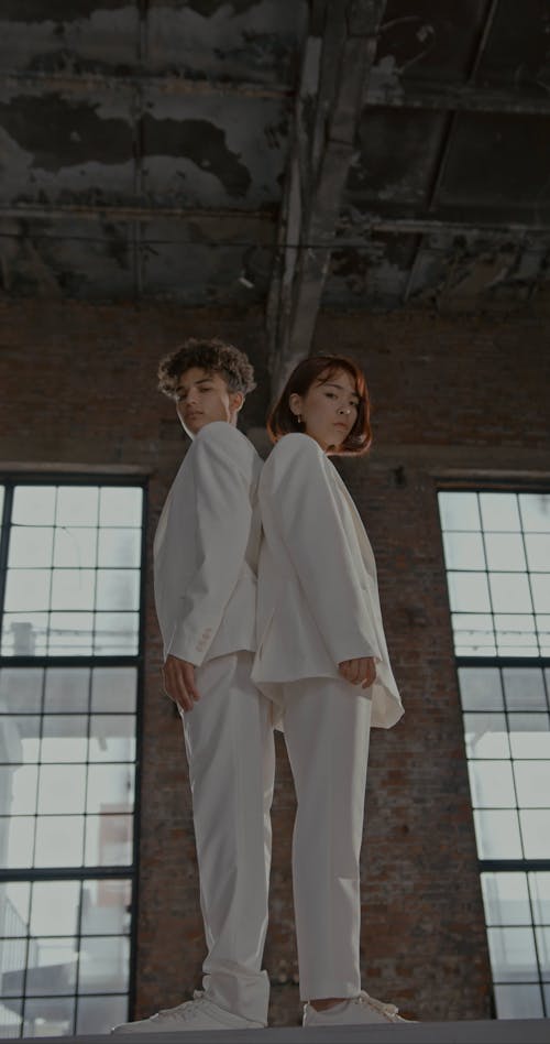 Low Angle View on Standing Man and Woman in White Suits