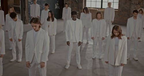 People in White Suits Raising Their Heads
