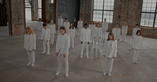 People in White Suits Standing and Walking Around