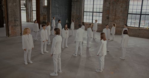 People in White Suits Standing and Turning
