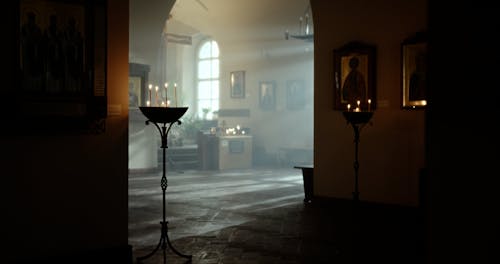 A Religious Woman Lighting a Candle in a Church 