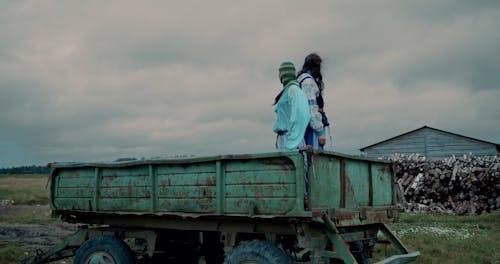 Man and Woman Standing on Trailer