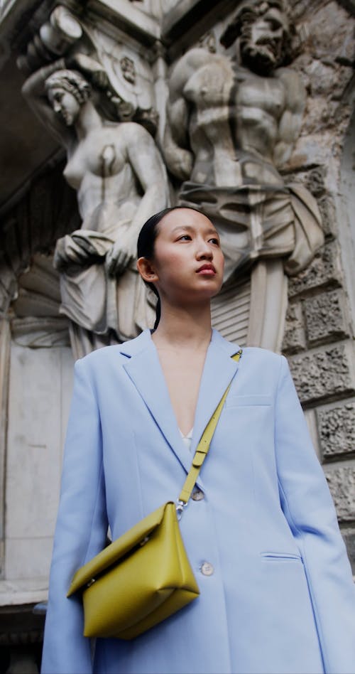 Sculptures on Wall behind Woman in Suit