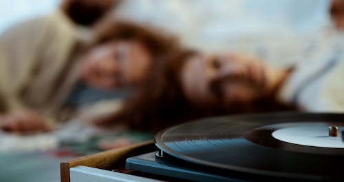 Young Women Listening to a Record Player While Lying Down