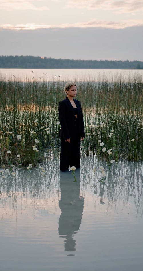 Woman in Suit among Flowers in Water