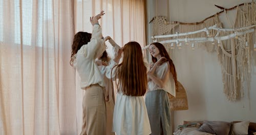Young Women Dancing Together by a Window
