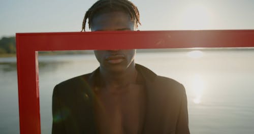 Man with Black Hair Holding Frame in Water