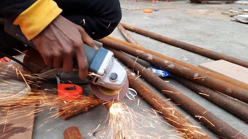 Person Grinding Pipes with Grinder