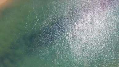 top view of a turquoise sea and a sandy beach