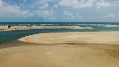 drone footage of a sandy beach under a cloudy sky