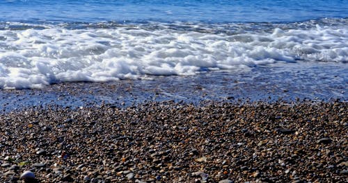 Waves Reaching the Shore on a Pebble Beach 