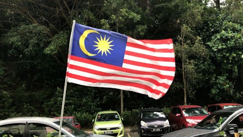 Close-up of a Malaysian Flag in a Parking Lot