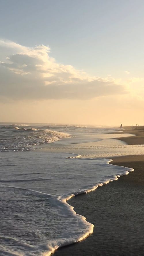 Waves Reaching the Shore on a Sandy Beach