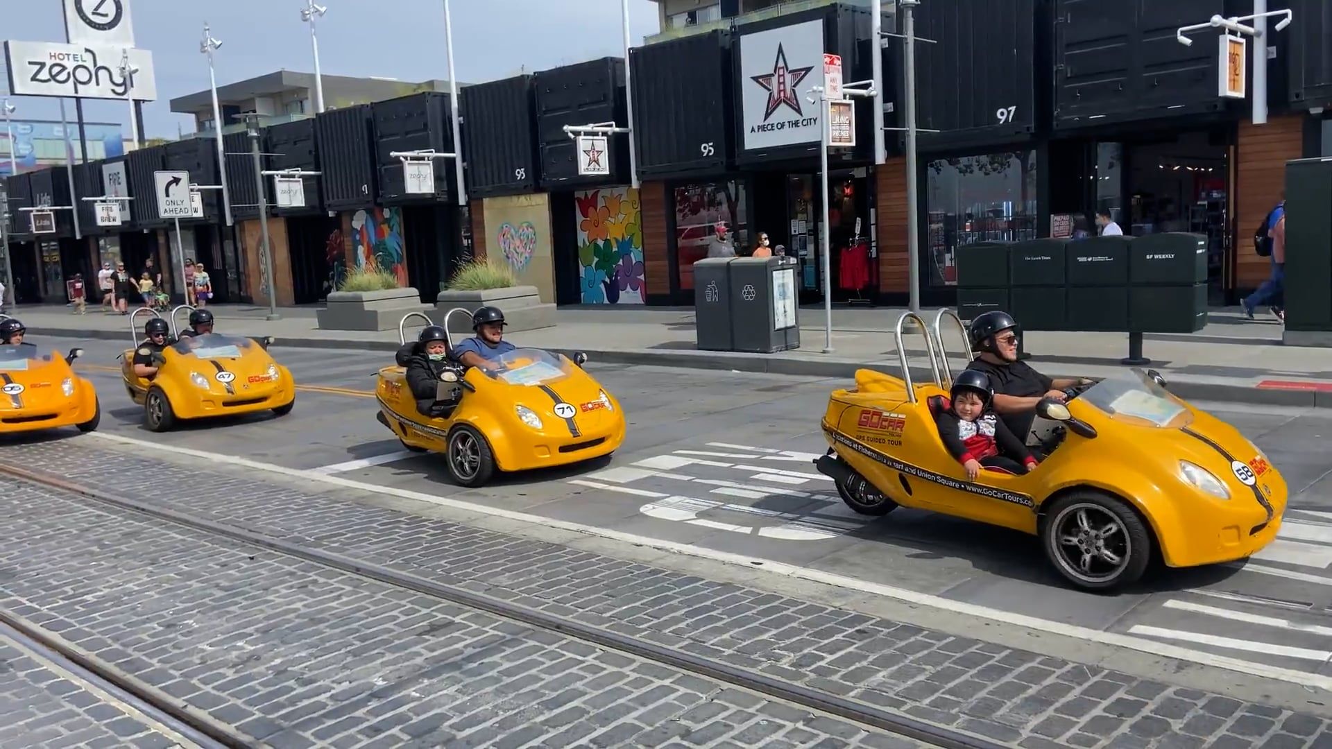 A cinematic shot of a three-wheel vehicle navigating a bustling city, highlighting urban mobility.