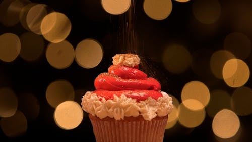 Close up Shot of Glitter Sugar Falling on a Cupcake 