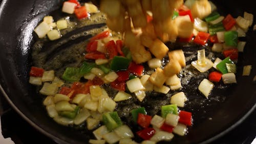 Close up on Adding Ingredients to Food Cooked on Pan