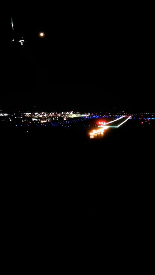 Airplane Landing on Runway Illuminated at Night