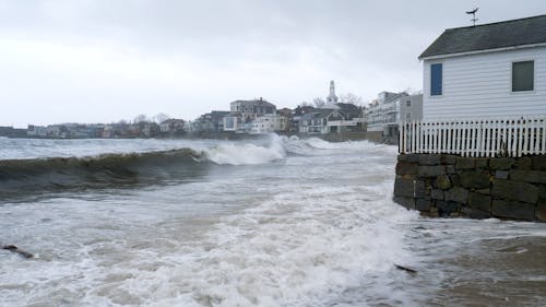 Waves Crashing on the Shore of a Coastal Town 