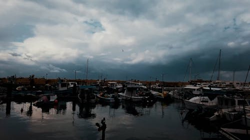 Boats Moored in a Harbour under a Cloudy Sky 