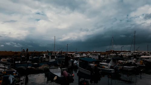 Boats and Ships in a Port under a Cloudy Sky