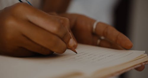 Close-up of Woman Writing in Notebook