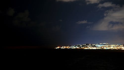 Time Lapse of Moving Clouds over a Coastal City at Night