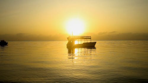 Boat in Sea at Sunrise