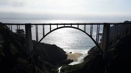 Drone Footage of an Arc Bridge by the Sea