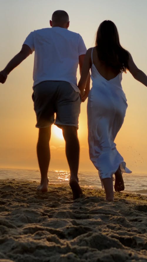 Couple Running and Hugging on Beach in Sunset