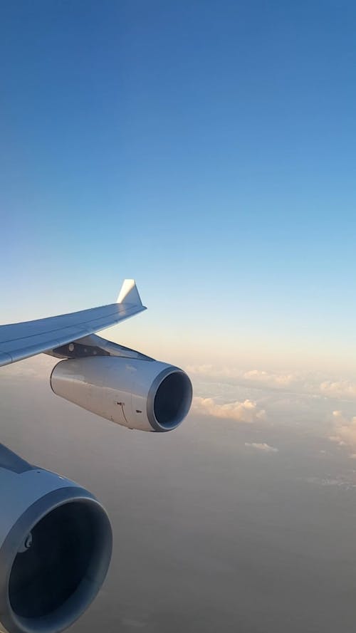 Window View from an Airplane Flying above the Clouds