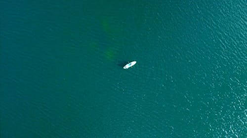 View from Moving Drone of People on Boat Floating on Ocean 