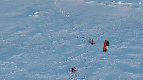 Drone Footage of People Preparing Snowkiting Gear 