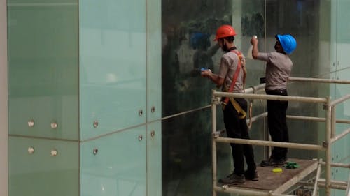 Workers Cleaning Glass Panels
