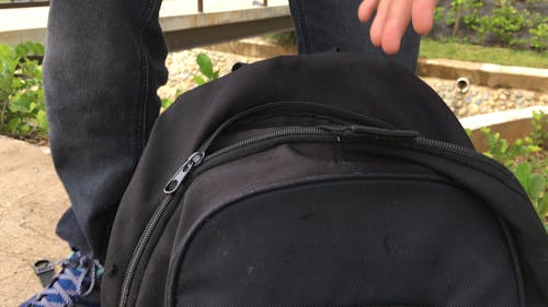 Boy Placing Tablet  Inside A Backpack