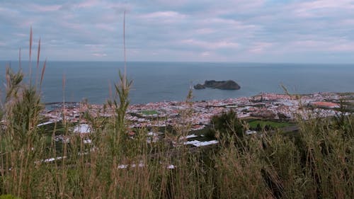 View of a Coastal Town under a Cloudy Sky 