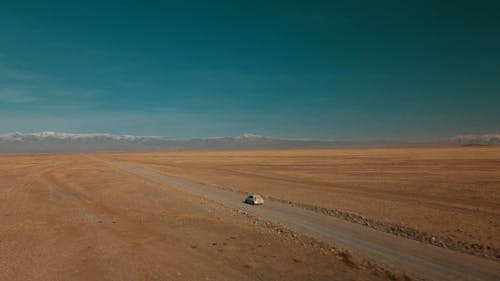 Drone Video of a Car Driving on a Remote Desert Road