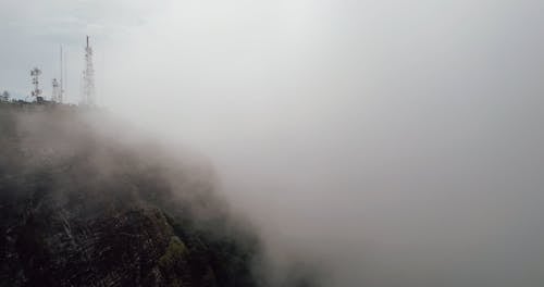 A Mountain Cliff Surrounded by Low Clouds 