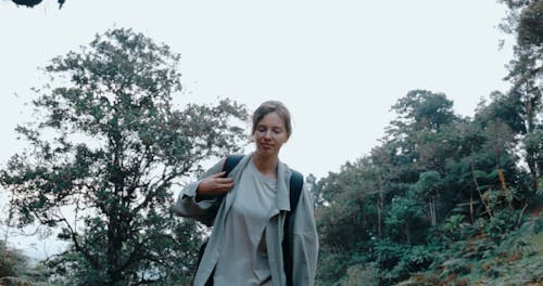 Front View of a Female Backpacker Hiking in a Forest