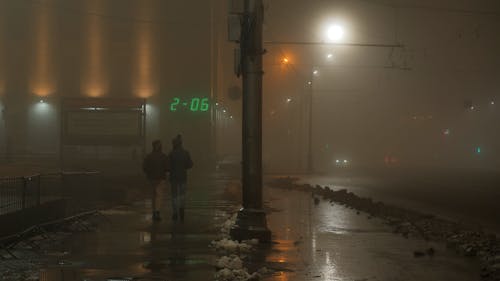 A Couple Walking in Sidewalk at Night