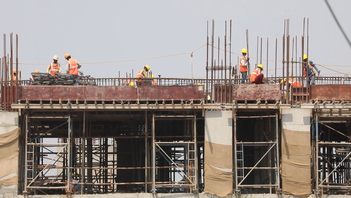 Construction workers in hard hats building steel framework