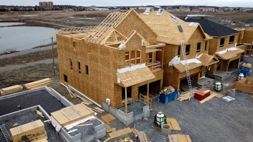 Drone Footage of Wooden Houses under Construction 