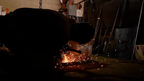 A Worker Cutting Metal using an Angle Grinder 