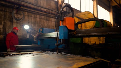 A Factory Worker Operating a Plasma Cutting Machine 