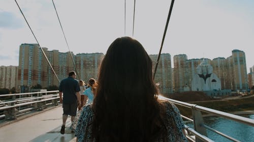 Back View of a Woman Walking on a Bridge 