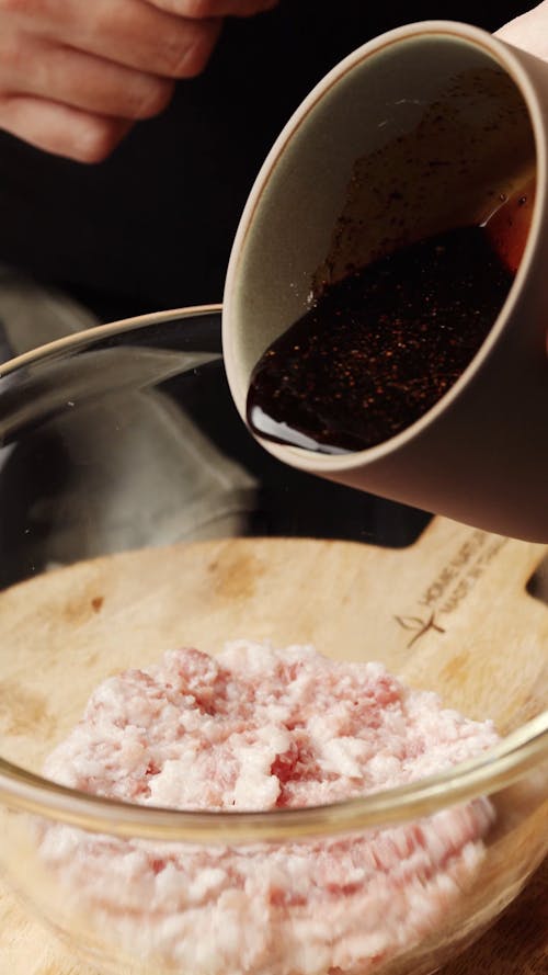 Pouring Sauce into Bowl with Meat