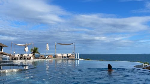 Time Lapse of a Woman Swimming in a Pool under a Cloudy Sky