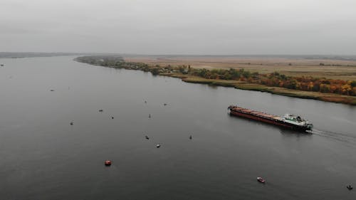 Drone Footage of a Cargo Ship and Small Boats in a River