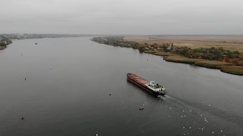 Drone Video of a Cargo Ship and Small Boats in a River